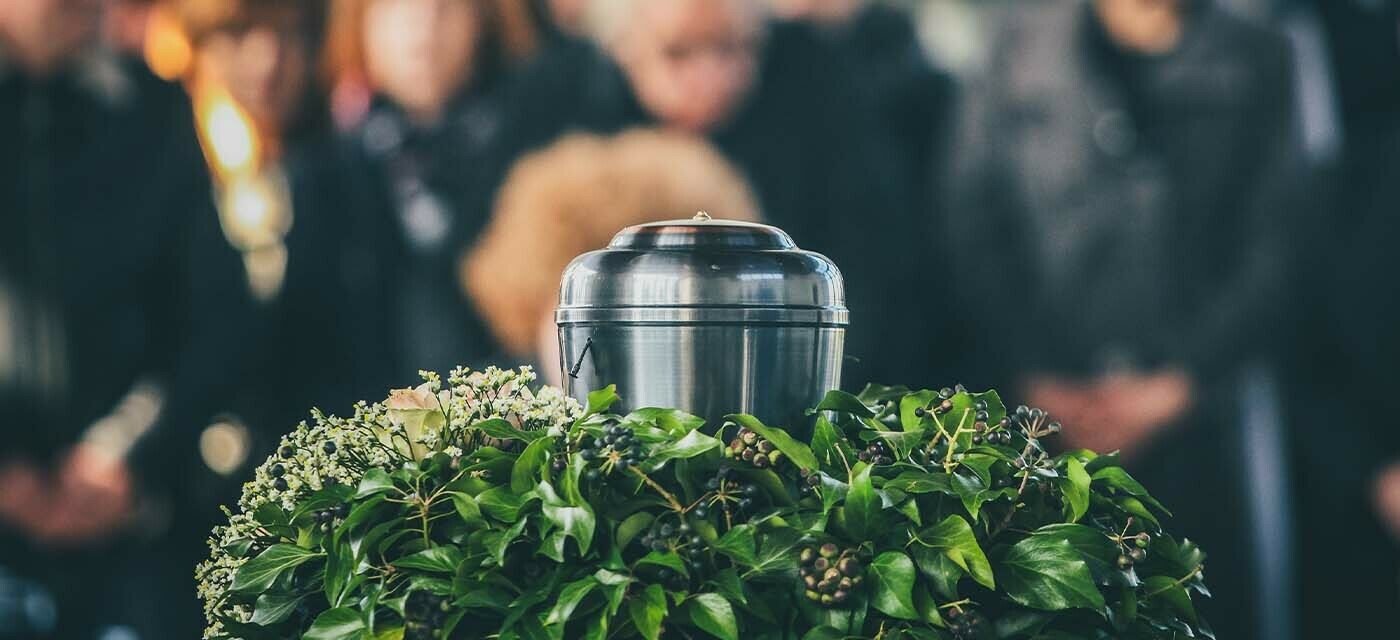 Cremation container surrounded by grieving family members