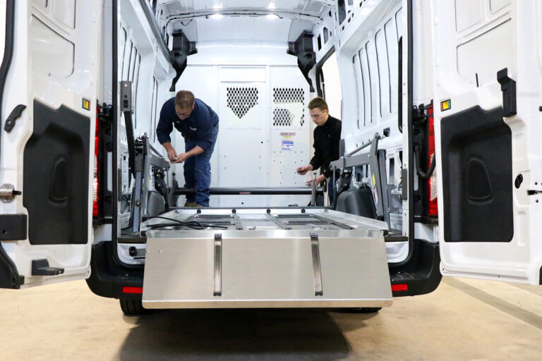2 individuals installing the lower deck of the DD2000-XLC into a Ford e-Transit