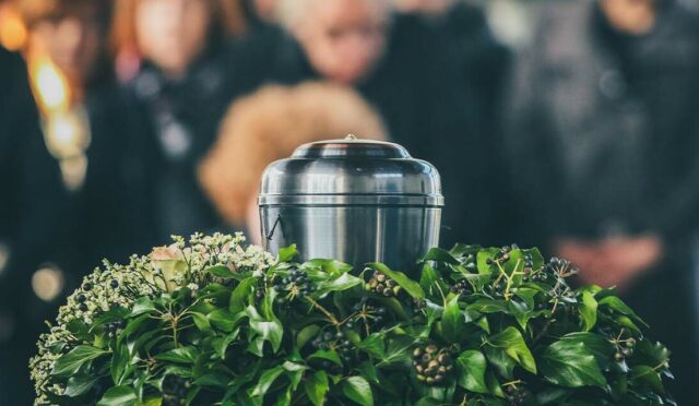 Cremation container surrounded by grieving family members